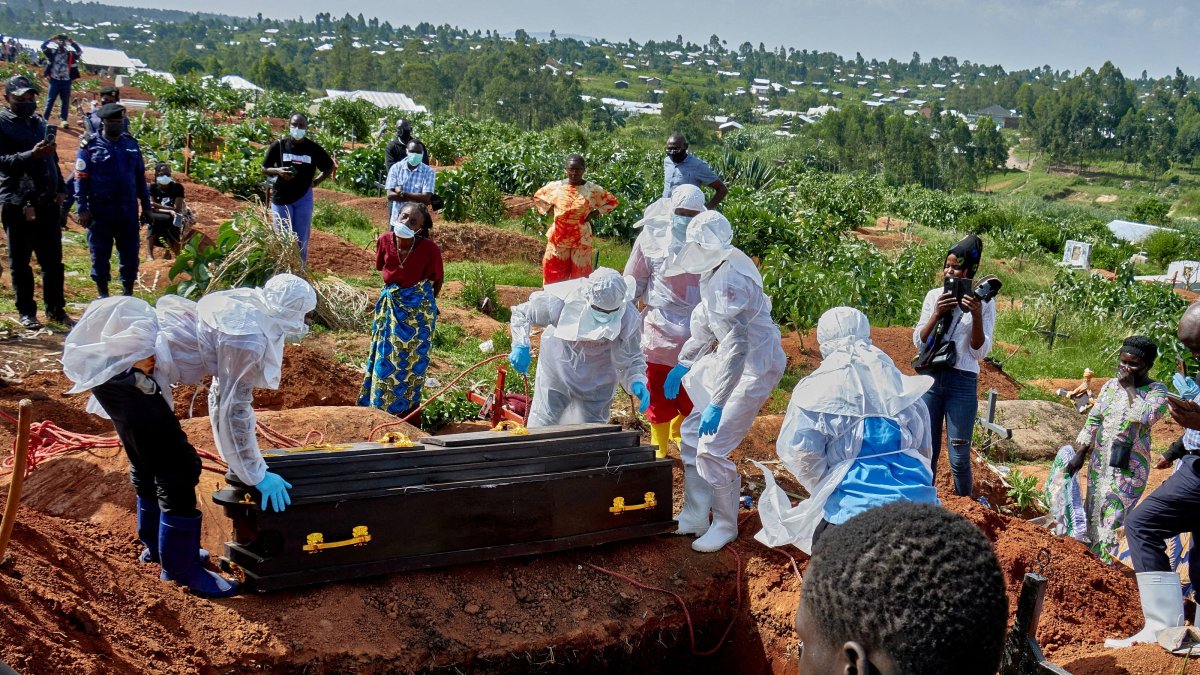 Red Cross workers wearing personal protective equipment (PPE) prepare to lower the coffin of an Ebola virus victim, at the Nyamurongo cemetery, Bunia, DRC, May 26, 2026. (Reuters Photo)