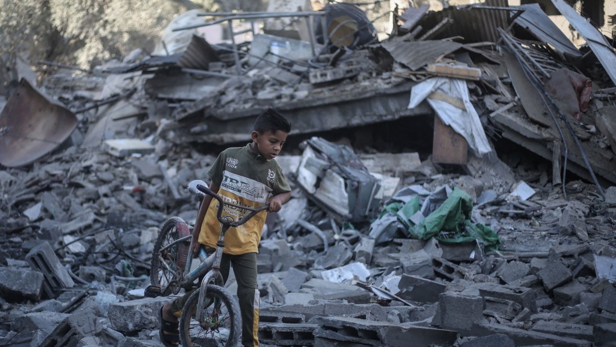 A Palestinian boy walks his bicycle through the rubble of a destroyed building after it was targeted by Israeli strikes the previous night, in Deir al-Balah, central Gaza Strip, July 29, 2026. (AFP Photo)