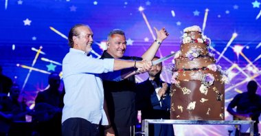 Greek singer Antonis Remos (R) and AYG Group Chair Mehmet Aygün cut a cake onstage during the 10th anniversary celebration of the Titanic Hotel in Bodrum, Muğla, Türkiye, July 30, 2026. (Photo courtesy of Titanic Hotel)