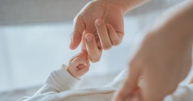 A mother holds the hand of a little baby. (Shutterstock Photo)