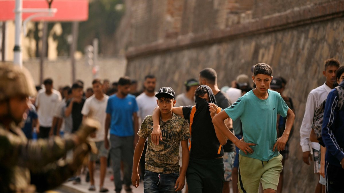 A Spanish soldier monitors a group of migrants on their way back towards the Moroccan border, following their illegal crossing into Spanish territory, Ceuta, Spain, Aug. 1, 2026. (AFP Photo)