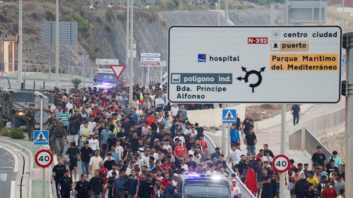Police officers and Spanish soldiers escort a big group of migrants to the border to take them out of Spain, after mass crossings of migrants on foot and by sea from Morocco into Spanish territory, Ceuta, Spain, Aug. 1, 2026. (Reuters Photo)