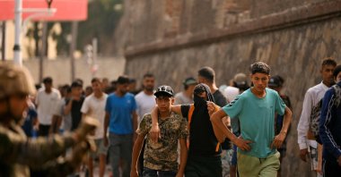 A Spanish soldier monitors a group of migrants on their way back towards the Moroccan border, following their illegal crossing into Spanish territory, Ceuta, Spain, Aug. 1, 2026. (AFP Photo)