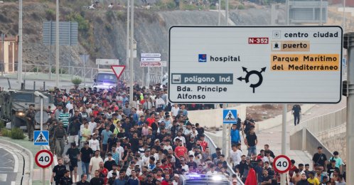 Police officers and Spanish soldiers escort a big group of migrants to the border to take them out of Spain, after mass crossings of migrants on foot and by sea from Morocco into Spanish territory, Ceuta, Spain, Aug. 1, 2026. (Reuters Photo)