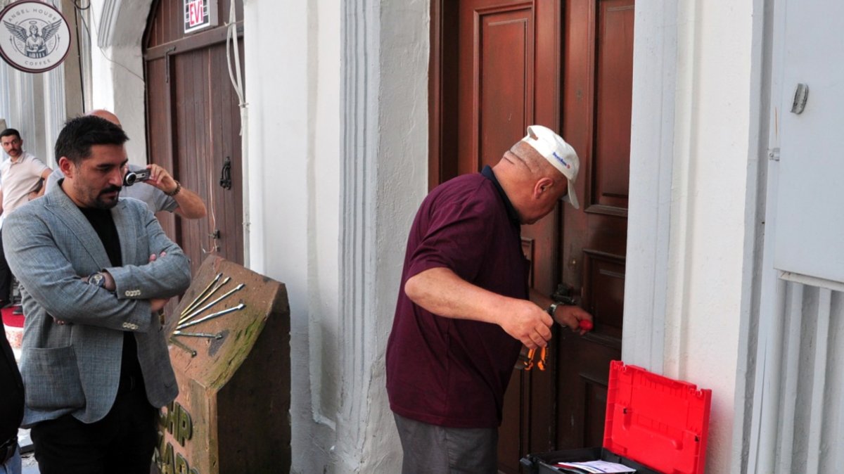 A locksmith opens the door of CHP offices kept locked by the pro-Özel former administration as the new local chair, Muhammet Baran Karahan (L), looks on, Kars, eastern Türkiye, Aug. 1, 2026. (AA Photo)