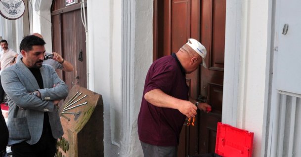 A locksmith opens the door of CHP offices kept locked by the pro-Özel former administration as the new local chair, Muhammet Baran Karahan (L), looks on, Kars, eastern Türkiye, Aug. 1, 2026. (AA Photo)