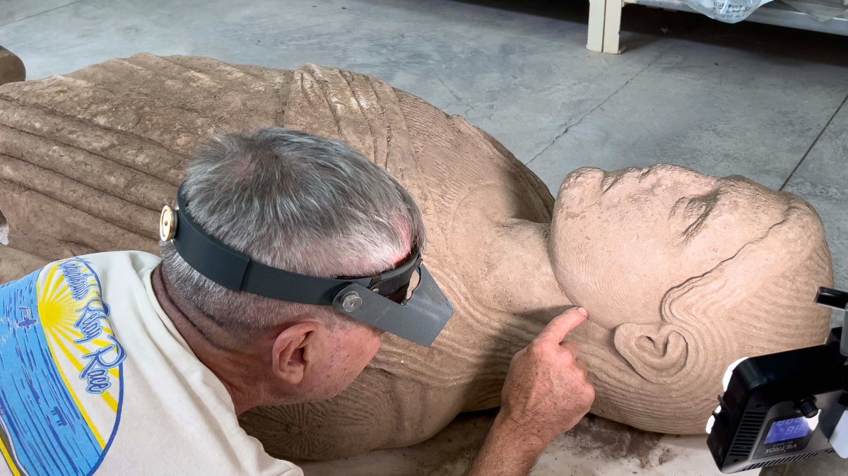 An expert works on a monumental marble statue of a young man dating back about 2,500 years, Manisa, Türkiye, Aug. 3, 2026. (AA Photo)