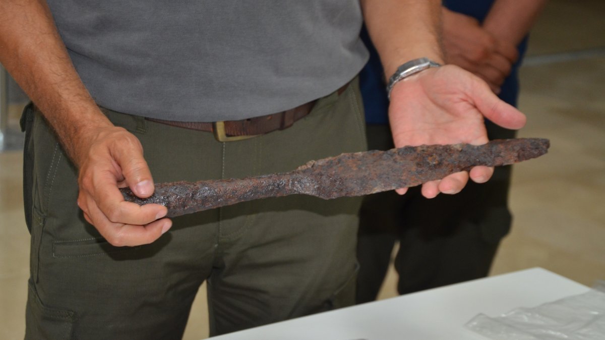 An expert holds an artifact discovered at the historic site of Malazgirt, Muş, Türkiye, July 31, 2026. (AA Photo)