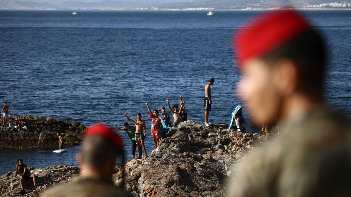 Members of the Spanish army watch a group of migrants near the border post of Spain's northern African enclave of Ceuta, Spain, Aug. 2, 2026. (AFP Photo)