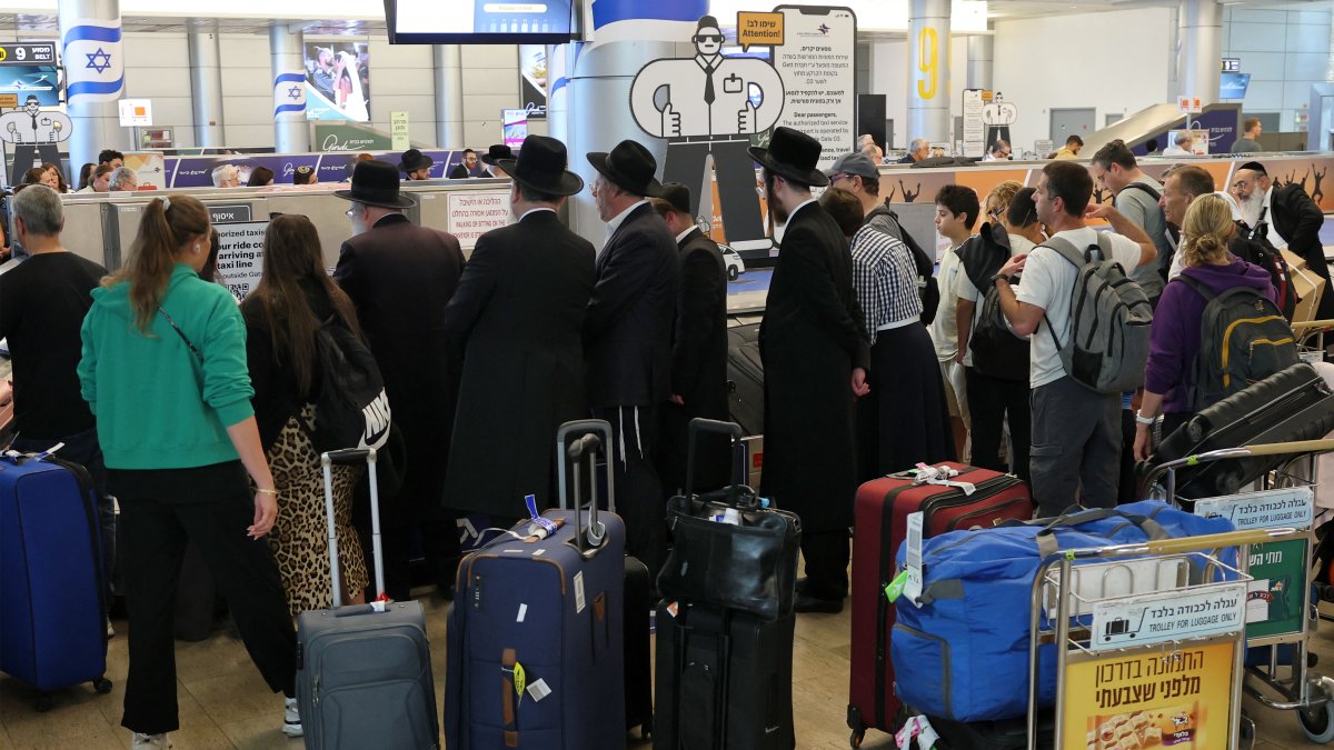 Travellers wait for their luggage at the belt upon arrival at Israel's central Ben Gurion Airport, June 25, 2025. (AFP Photo)