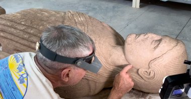 An expert works on a monumental marble statue of a young man dating back about 2,500 years, Manisa, Türkiye, Aug. 3, 2026. (AA Photo)