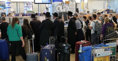 Travellers wait for their luggage at the belt upon arrival at Israel's central Ben Gurion Airport, June 25, 2025. (AFP Photo)