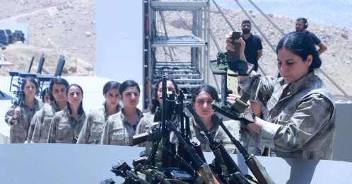 PKK members line up to put their weapons into a pit during a disarmament ceremony in Sulaimaniyah, northern Iraq, July 11, 2025. (AFP Photo)