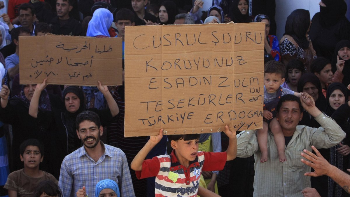 Syrian refugees hold a placard thanking Türkiye and President Recep Tayyip Erdoğan at a camp set up by the Turkish Red Crescent, Hatay, southern Türkiye, June 10, 2011. (AP Photo)