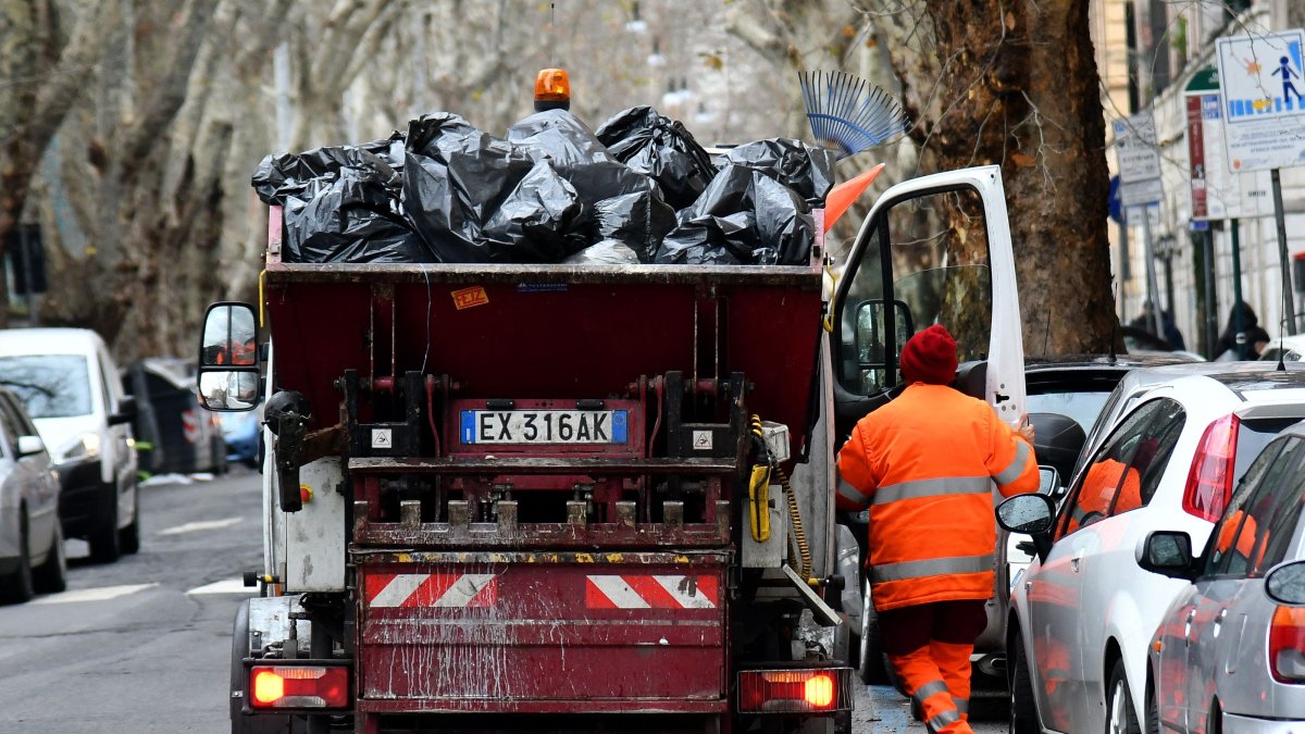 An employee of Rome's garbage collection unit getting on his truck, Rome, Jan.11, 2018. (AFP Photo)
