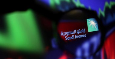 The Saudi Aramco logo and stock graph are seen through a magnifier displayed in this illustration taken on Sept. 4, 2022. (Reuters Photo)