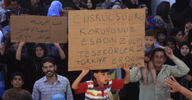 Syrian refugees hold a placard thanking Türkiye and President Recep Tayyip Erdoğan at a camp set up by the Turkish Red Crescent, Hatay, southern Türkiye, June 10, 2011. (AP Photo)