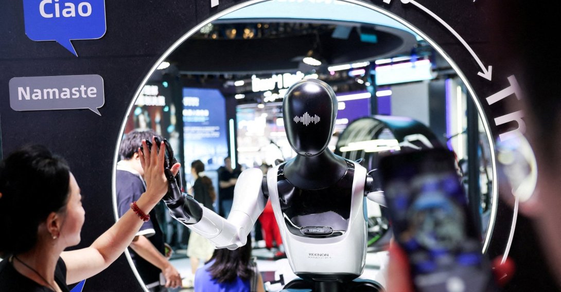 A visitor high-fives a humanoid robot at the Keenon Robotics booth during the World Artificial Intelligence Conference (WAIC), Shanghai, China, July 18, 2026. (Reuters Photo)