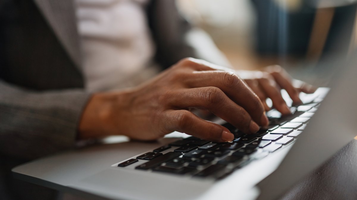 A close-up view of a woman working on a laptop. (Shutterstock Photo)