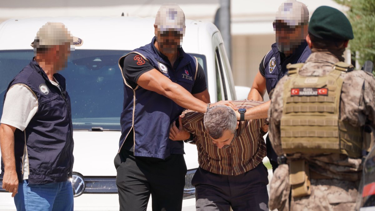 Police officers escort Burkay Karatepe as he is brought to a courthouse, Muğla, southwestern Türkiye, Aug. 5, 2026. (AA Photo)