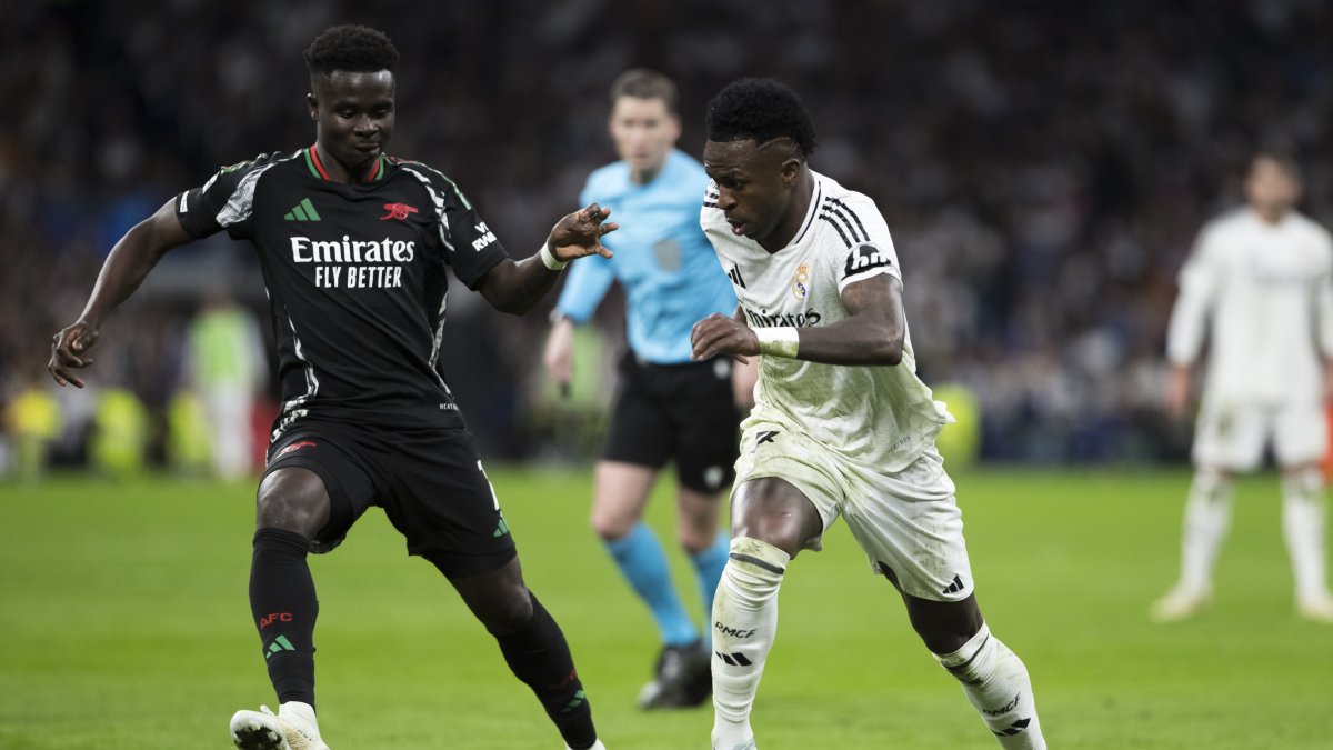 Real Madrid's Vinicius Junior (R) and Arsenal's Bukayo Saka in action during the UEFA Champions League quarterfinal second-leg match at Santiago Bernabeu Stadium, Madrid, Spain, April 16, 2025. (Getty Images Photo)
