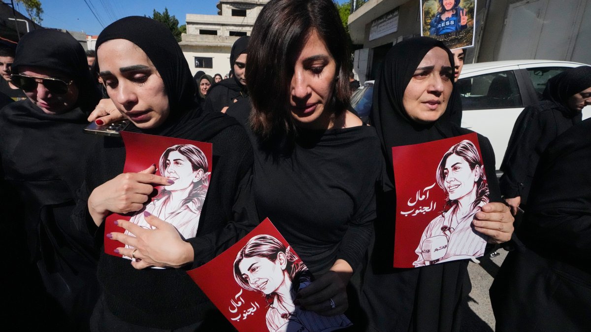 Mourners hold posters that show portraits of Lebanese journalist Amal Khalil, who was killed in an Israeli airstrike, during her funeral procession in the village of Baysariyeh, southern Lebanon, April 23, 2026. (AP Photo)