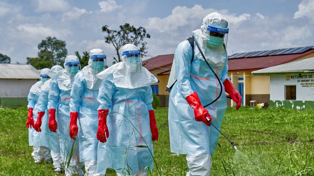 Red Cross workers walk in a formation as they disinfect Rwampara General Hospital before handling the body of a person who died of Ebola, in Rwampara, Congo, May 21, 2026. (Reuters Photo)