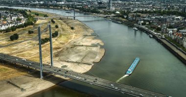 An inland waterway vessel carrying a light load passes via the Rhine, Duesseldorf, Germany, Aug. 5, 2026. (AP Photo)