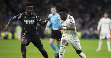 Real Madrid's Vinicius Junior (R) and Arsenal's Bukayo Saka in action during the UEFA Champions League quarterfinal second-leg match at Santiago Bernabeu Stadium, Madrid, Spain, April 16, 2025. (Getty Images Photo)