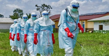Red Cross workers walk in a formation as they disinfect Rwampara General Hospital before handling the body of a person who died of Ebola, in Rwampara, Congo, May 21, 2026. (Reuters Photo)