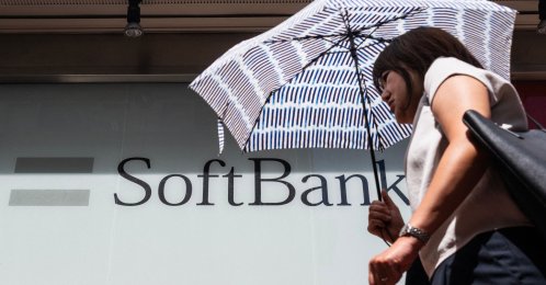 A commuter walks past a Softbank logo on the side of a building, Tokyo, Japan, Aug. 6, 2026. (AFP Photo)