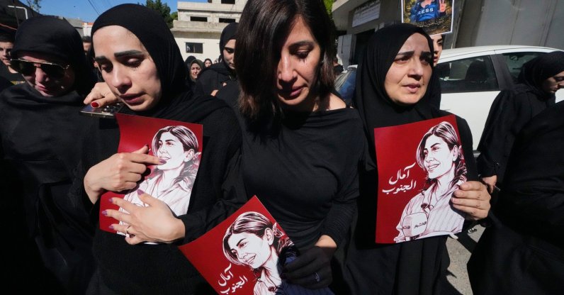 Mourners hold posters that show portraits of Lebanese journalist Amal Khalil, who was killed in an Israeli airstrike, during her funeral procession in the village of Baysariyeh, southern Lebanon, April 23, 2026. (AP Photo)