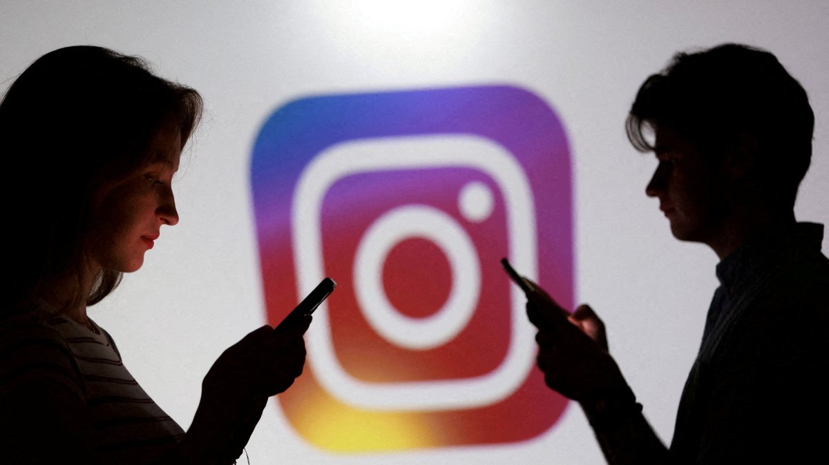 Teenagers pose for a photo while holding smartphones in front of an Instagram logo in this illustration created Sept. 11, 2025. (Reuters Photo)