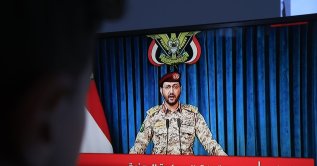 A person watches Houthi military spokesman Yahya Sarea deliver a televised statement, Sana'a, Yemen, Aug. 6, 2026. (EPA Photo)