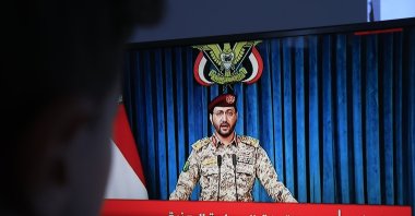 A person watches Houthi military spokesman Yahya Sarea deliver a televised statement, Sana'a, Yemen, Aug. 6, 2026. (EPA Photo)