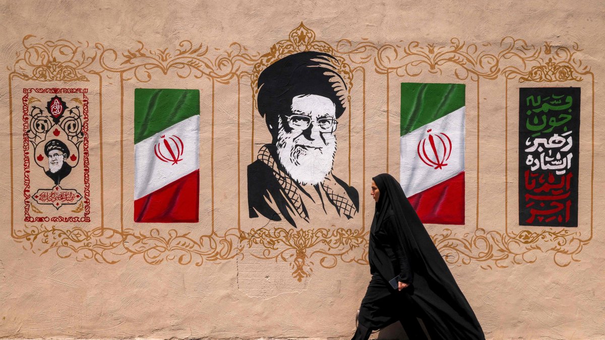 A woman walks past a mural depicting Iran's late supreme leader Ali Khamenei at Valiasr Square, Tehran, Iran, Aug. 8, 2026. (AFP Photo)