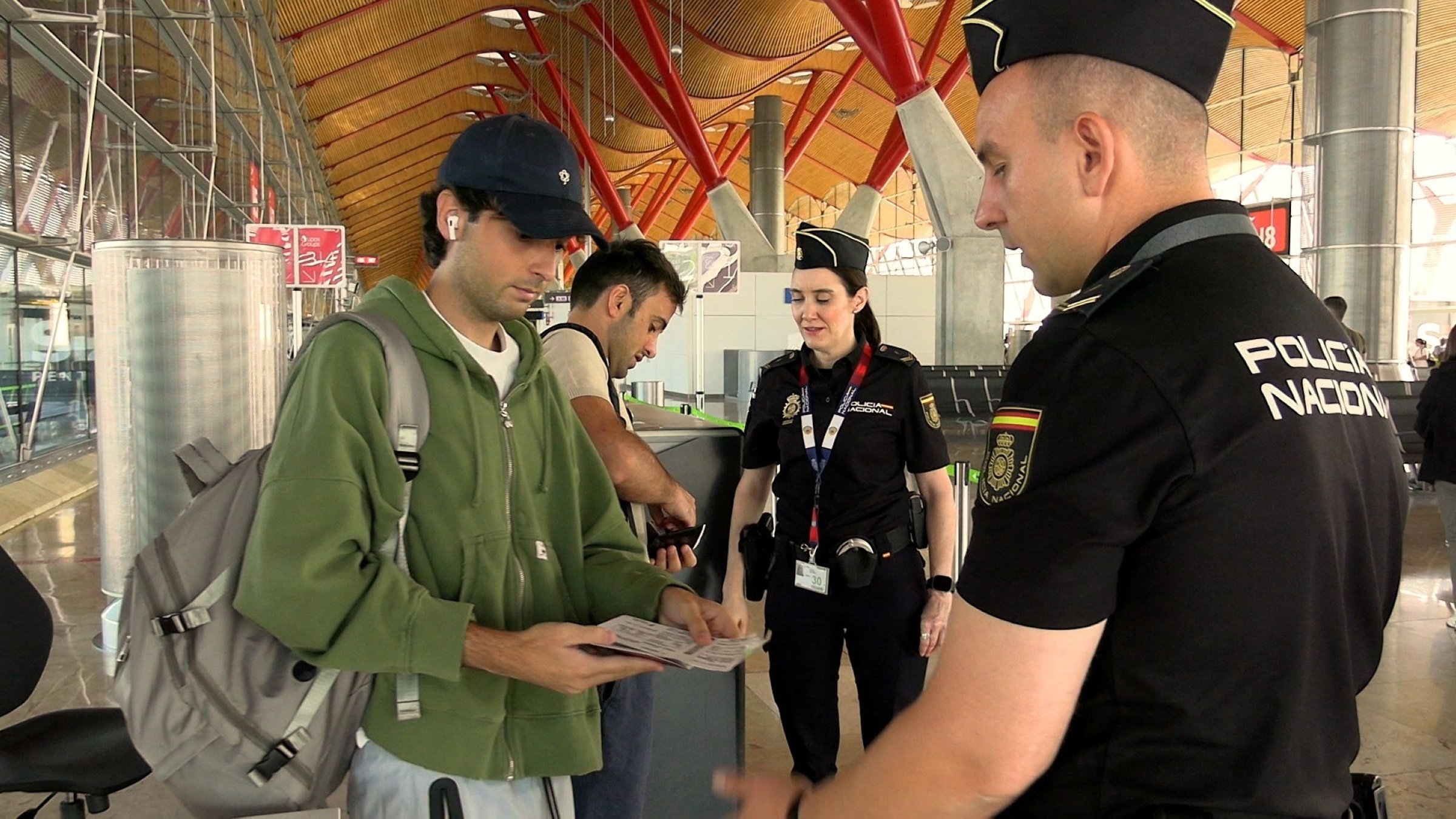 Spanish national police officers check the documents of travellers arriving from Italy, after Spain's government said it would establish border controls for flights and ships from Italy, at Madrid-Barajas Airport, Madrid, Spain, Aug. 8, 2026. (Reuters Photo)