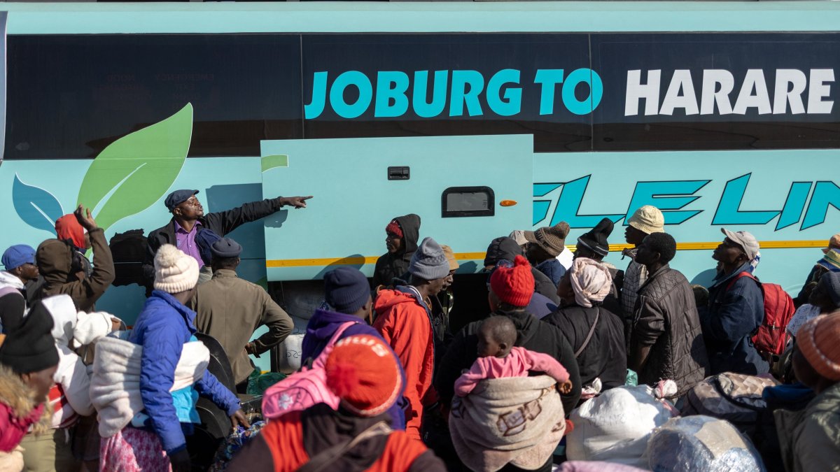 A bus driver gestures as people awaiting repatriation gather to board a bus headed to Zimbabwe at a repatriation center near the Beitbridge border crossing with Zimbabwe, Musina, South Africa, July 9, 2026. (AFP Photo)
