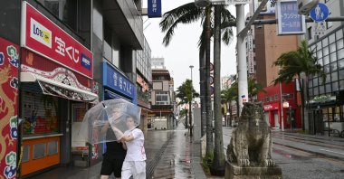 People walk with an umbrella in Naha, Okinawa Prefecture, Japan, Aug. 7, 2026. (Reuters Photo)