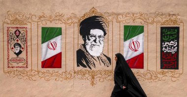 A woman walks past a mural depicting Iran's late supreme leader Ali Khamenei at Valiasr Square, Tehran, Iran, Aug. 8, 2026. (AFP Photo)