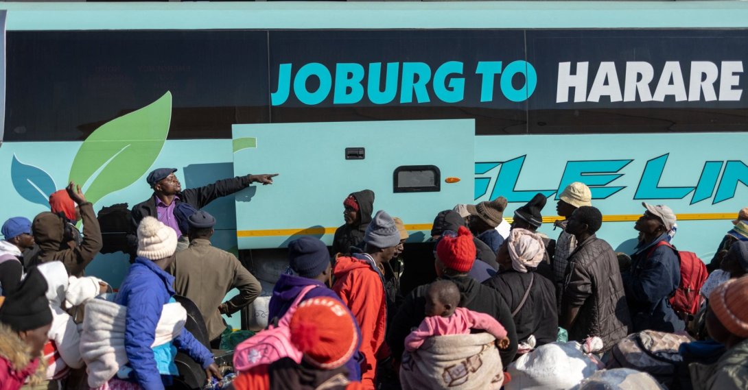 A bus driver gestures as people awaiting repatriation gather to board a bus headed to Zimbabwe at a repatriation center near the Beitbridge border crossing with Zimbabwe, Musina, South Africa, July 9, 2026. (AFP Photo)