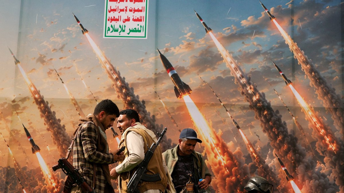 Houthi rebels stand on a platform against a banner depicting Houthi missiles in Sanaa, Yemen, July 31, 2026. (Reuters Photo)