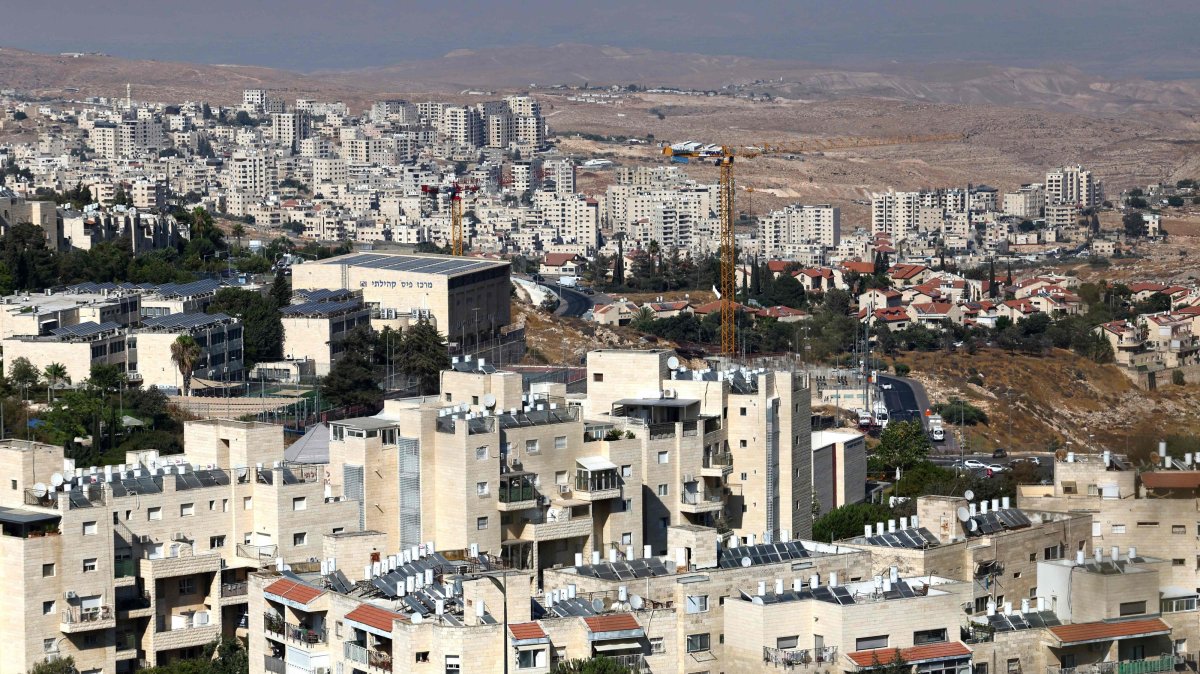 The illegal Israeli settlement of Pisgat Zeev (foreground) in the northern area of east Jerusalem and Israel's unlawful barrier separating the Palestinian town Hzma (background) are pictured in the occupied West Bank, Aug. 7, 2026. (AFP Photo)