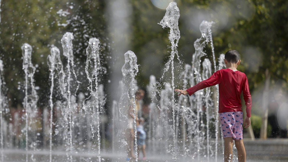 A child cools off in the jets of a fountain in Valencia, Spain, July 15, 2026. (EPA Photo)