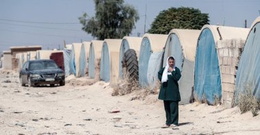 A displaced Syrian woman walks through the al-Talaeh displacement camp, Hasakeh, northeastern Syria, July 23, 2026. (AFP Photo)