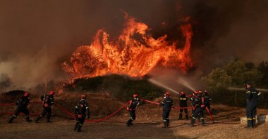 Firefighters work on a burning area near Loumpa, as wildfires hit West Attica, Greece, Aug. 3, 2026. (Reuters Photo)