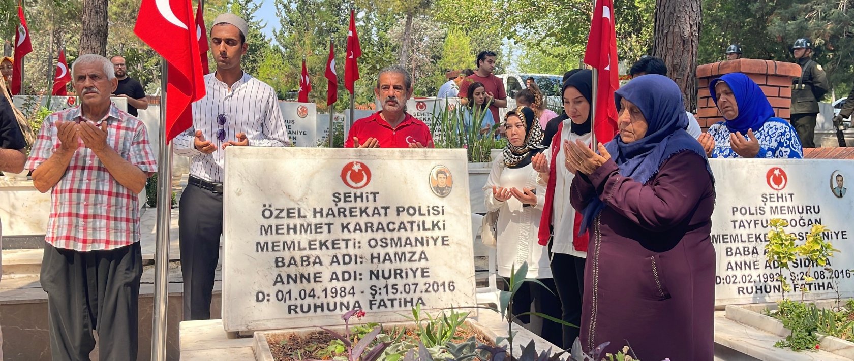 People pray by the grave of a police officer martyred during the 2016 coup attempt by terrorist group FETÖ, in Osmaniye, southern Türkiye, July 15, 2026. (İHA Photo) 