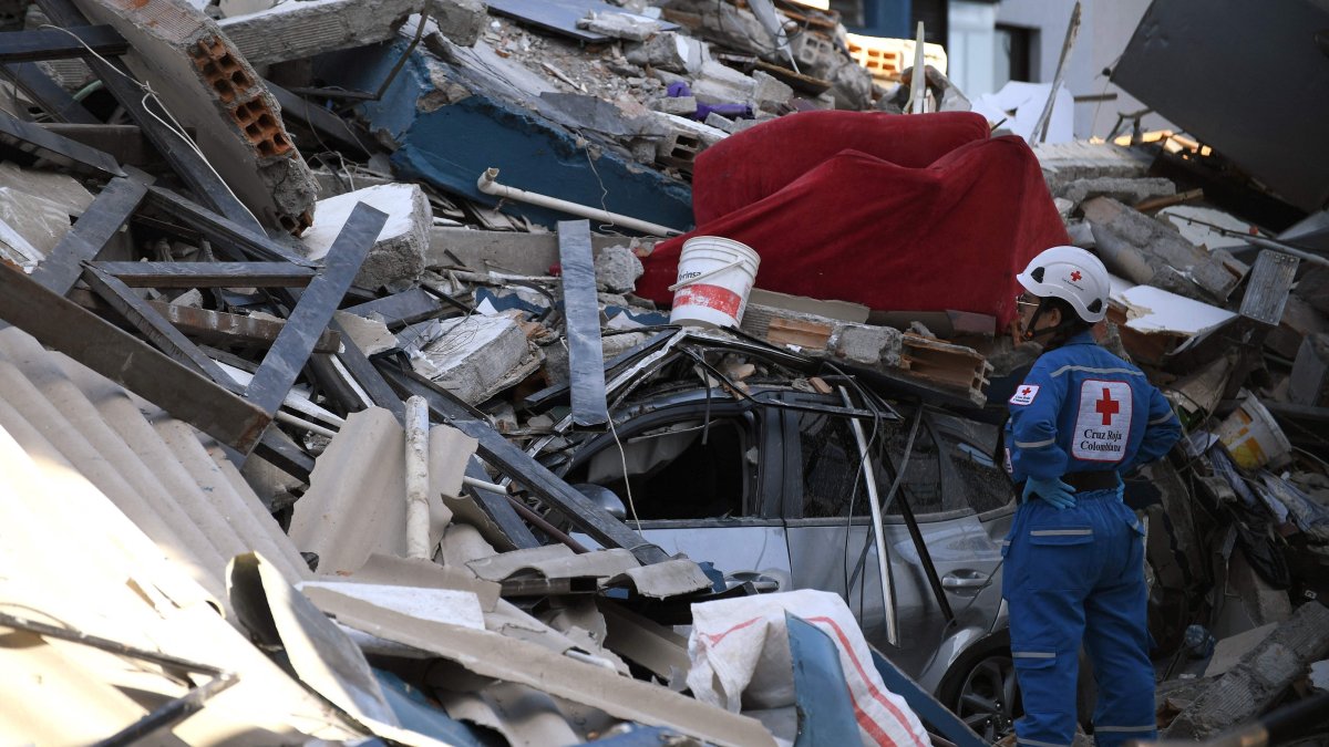 A Colombian Red Cross member looks for survivors amid the rubble of a collapsed building after an earthquake, Pereira, Colombia, Aug. 10, 2026. (AFP Photo)