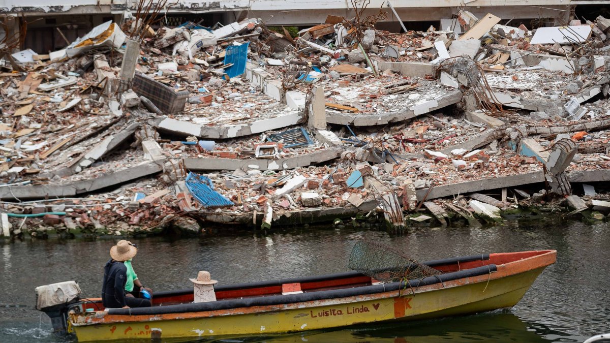 A person rides a boat beside a collapsed building, La Guaira, Venezuela, Aug. 9, 2026. (EPA Photo)