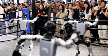 People watch humanoid robots dance at the Unitree booth during the World Artificial Intelligence Conference (WAIC), Shanghai, China, July 17, 2026. (Reuters Photo)